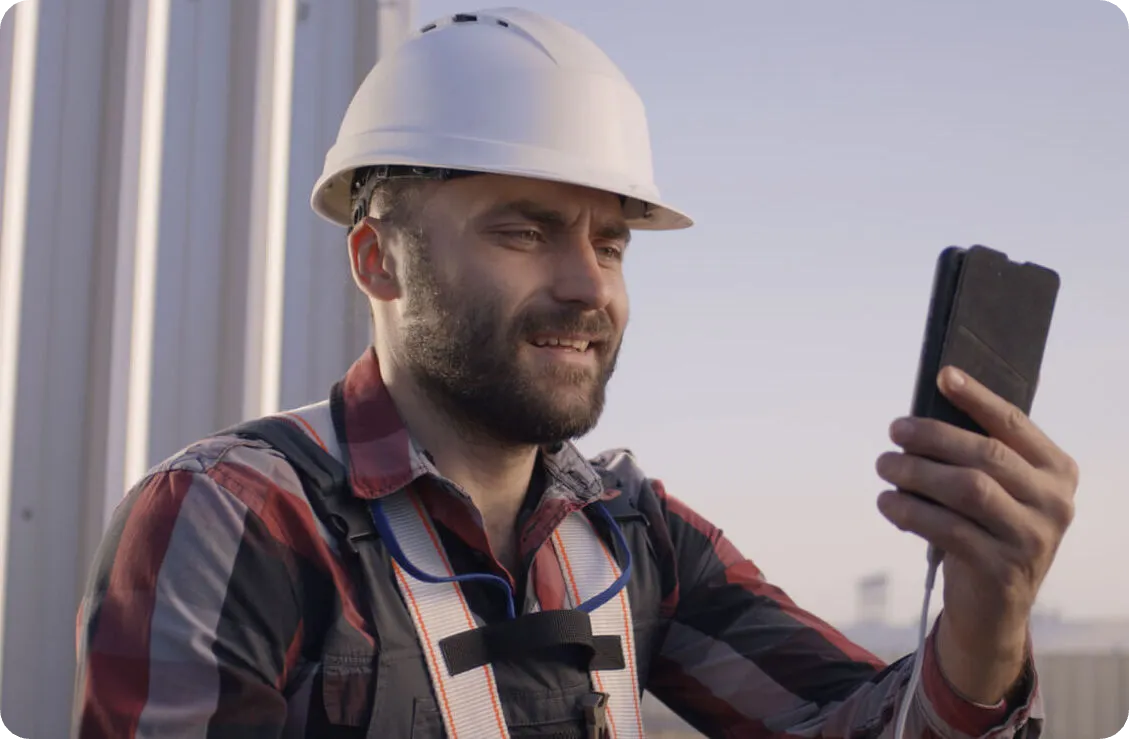Technician on a rooftop following instructions on his phone